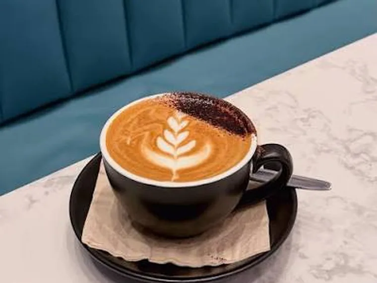A coffee with latte art, on a marble table
